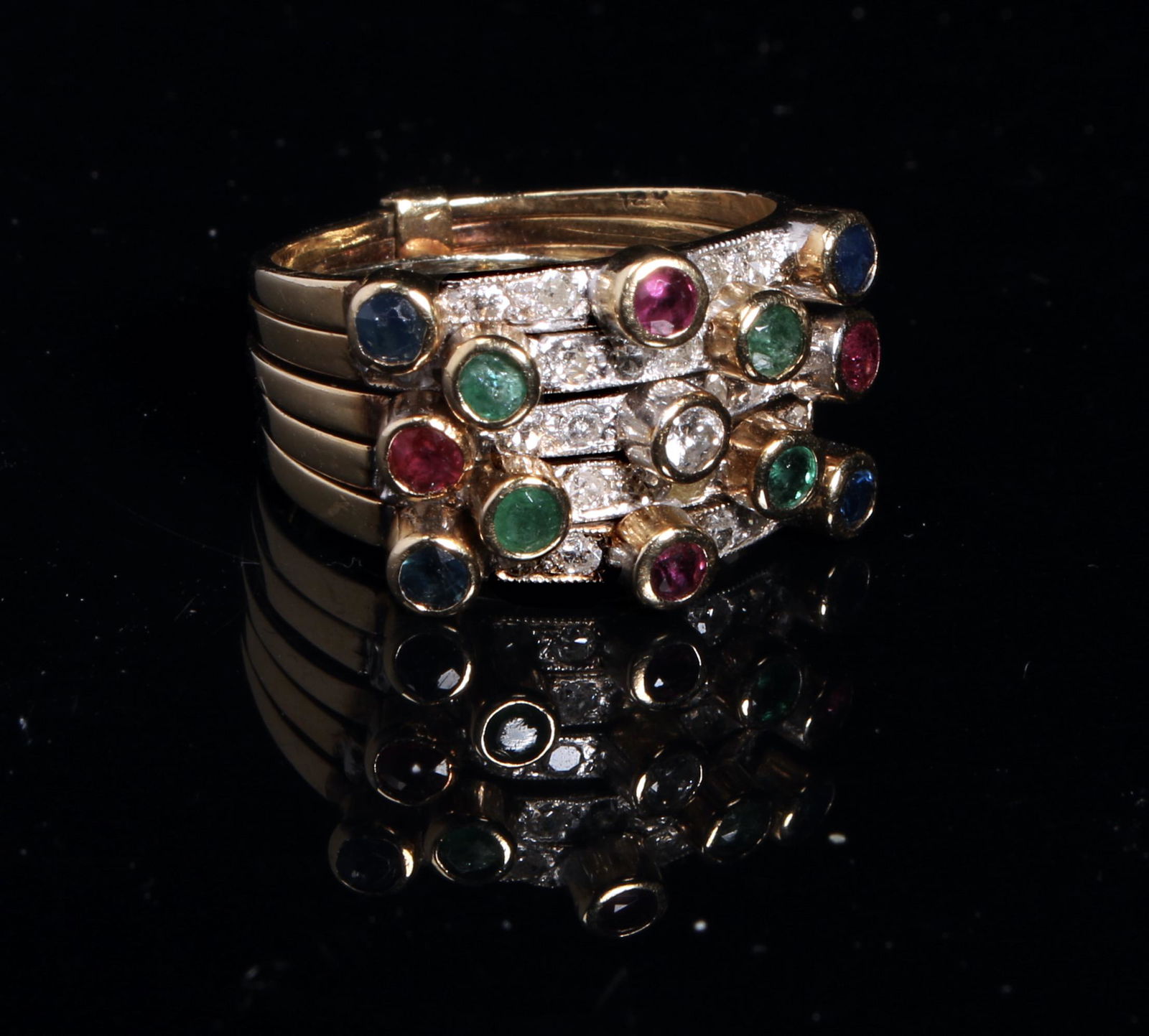 FIVE STACKING 14K RINGS WITH GEMSTONES: Timeless classic gemstone stacking rings, connected at the back of the shank with slide. Diamonds, rubies, and sapphires are bezel set on the five rings. 6g. Marked 14K. Provenance: Major NYC fa
