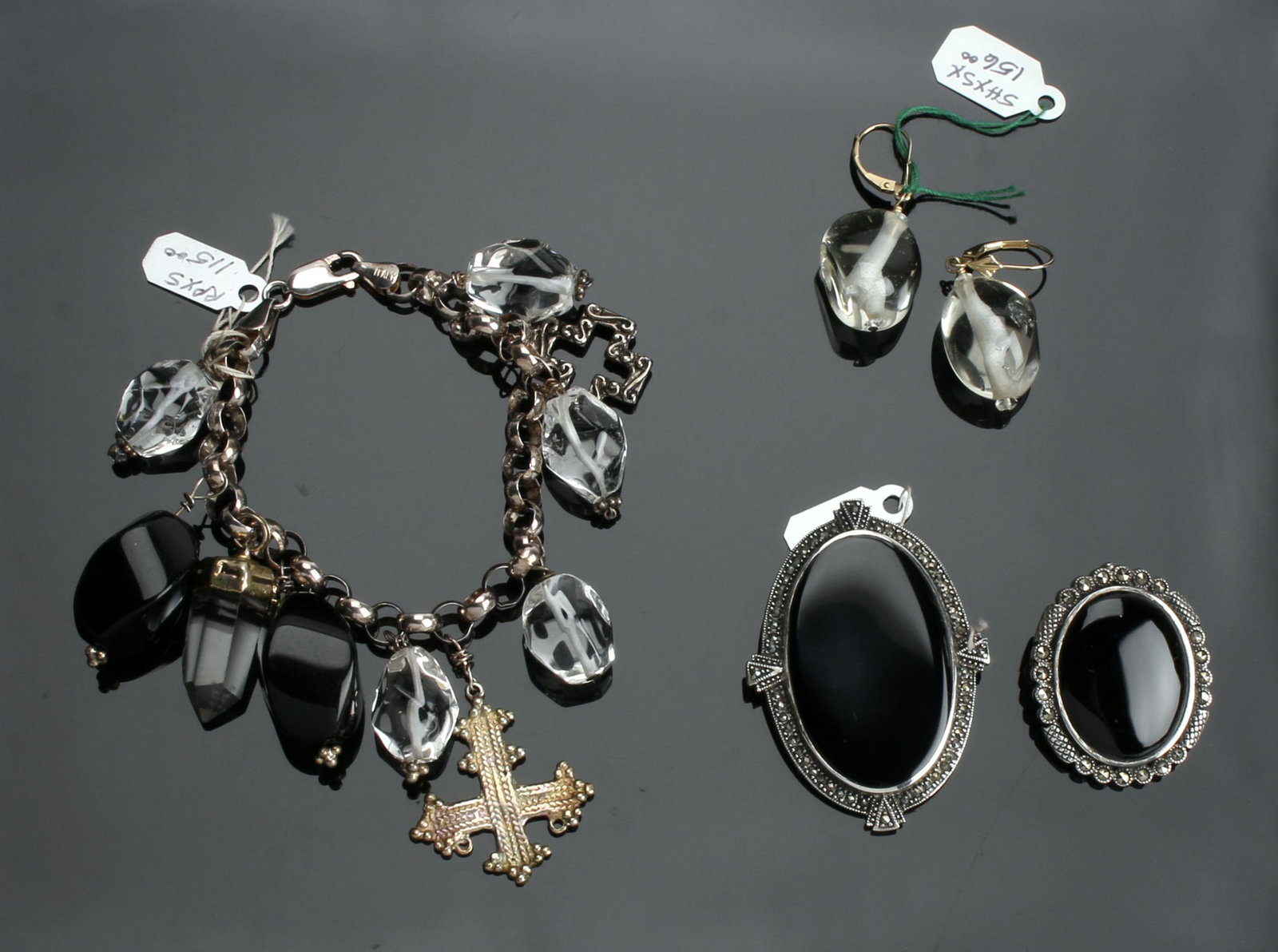 GOTHIC ECLECTIC CHARM BRACELET, EARRINGS, PINS: Charm bracelet is quartz, onyx, and crystal pendants in an electic fun gothic style. Pair of 14k smoky quartz drop earrings, and two marcasite and onyx pins. 95.2g.