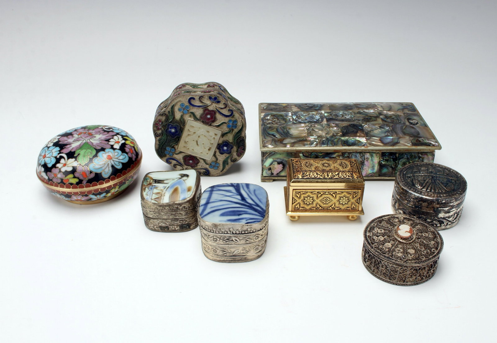 METAL BOXES FROM AROUND THE WORLD: A collection of metal boxes: abalone box from Mexico, silver, enamel and porcelain from China, cloisonné from Japan, Damascene from Spain,Cambodia, and a cameo filagree box. 5 1/2" $100