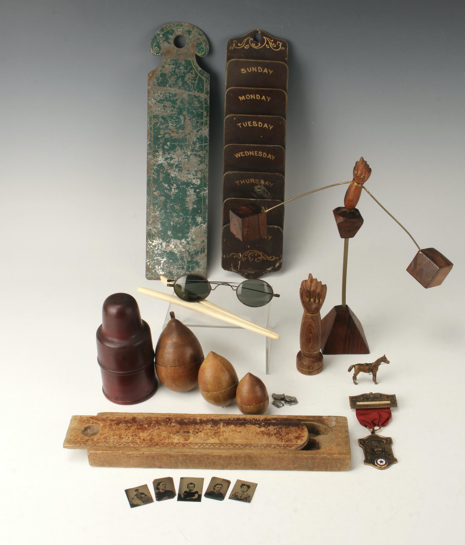 ASSORTED ANTIQUE & VINTAGE WOODEN TREEN LOT: Glove stretcher, vintage sunglasses, 3 nesting darning eggs, ink bottle inside a wooden container, 5 mini tin type photos, weekly organizer, balancing fig gesture and fig fist figure, thirteenth natio