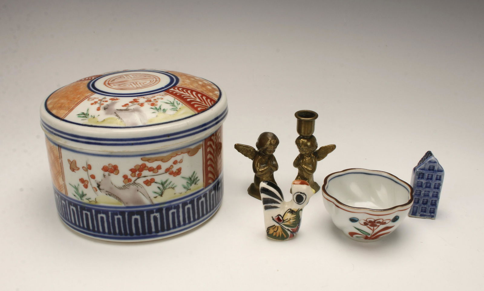 LOT OF PORCELAIN & COLLECTIBLE ITEMS: Lidded porcelain Chinese box with a character on the lid (inside of lid is broken). Small porcelain tea cup decorated in a flower on front and back, marked on the bottom. Two brass kneeling angels, on