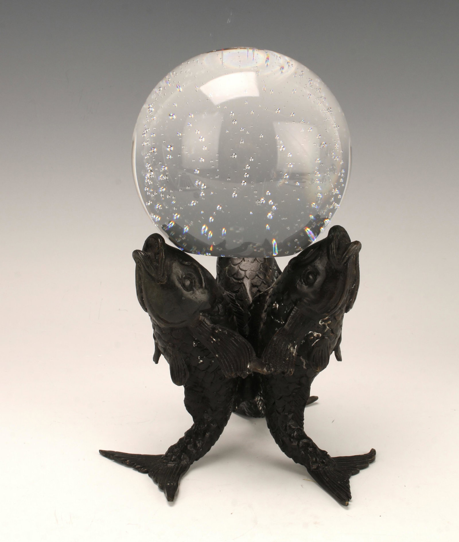 CONTROLLED BUBBLE PAPERWEIGHT ON DOLPHIN STAND: Large mid century modern controlled bubble paperweight rests atop tripod dolphin stand. Cast dolphin stand is marked R9. Paperweight has flat bottom so it can be freestanding. 4" X 7 1/2"