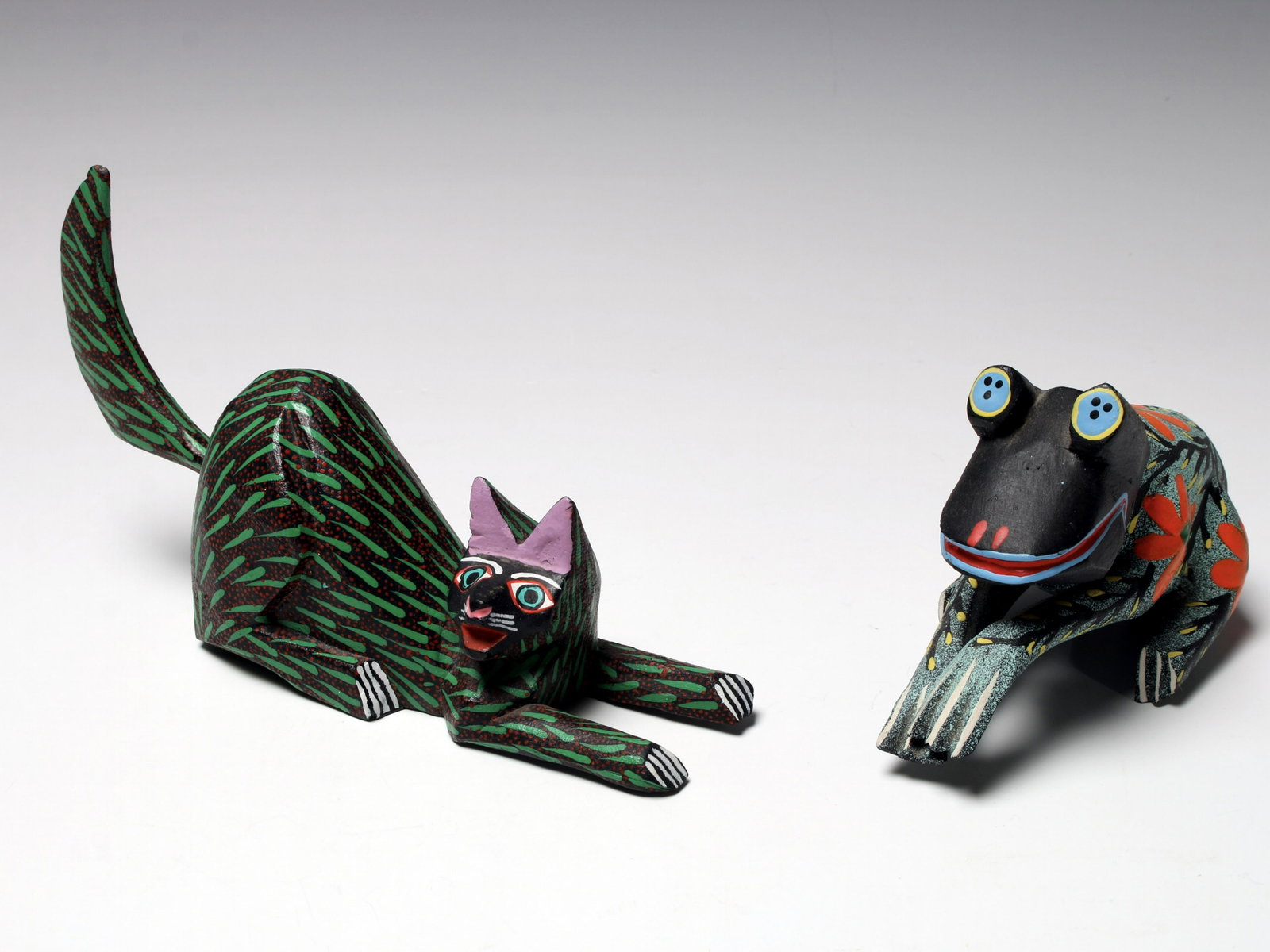 TWO OAXACAN FOLK ART ALEBRIJE FIGURES: Carved and colorfully painted wooden figures with in expressive poses. Cat signed Pedro Hernadez Cruz. 7 1/2" X 4" $100 - $200 Please contact us for high resolution images of this lot