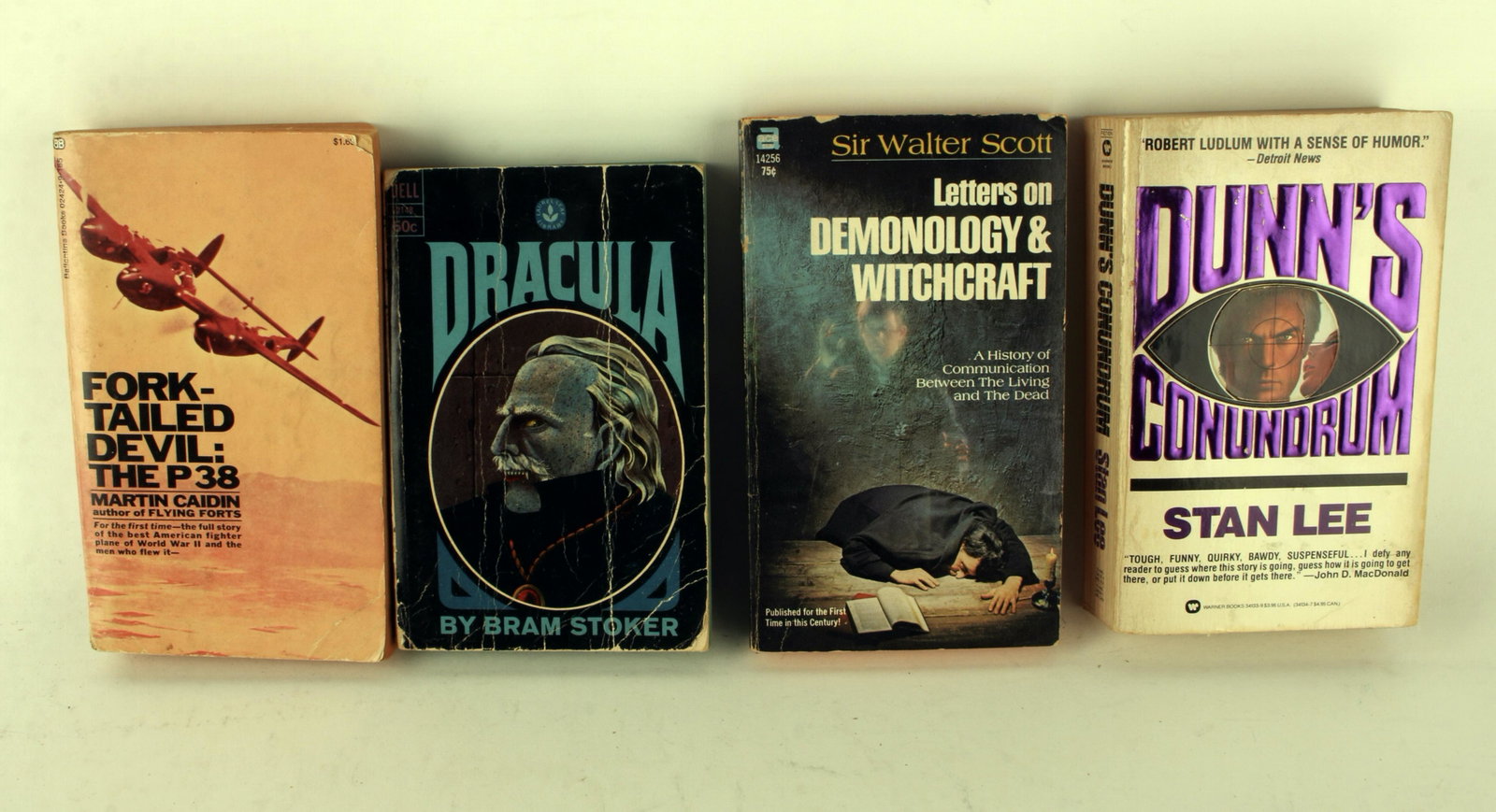 4 PAPERBACK THRILLER BOOKS: Dunn's Conundrum by Stan Lee, copyright 1985. Dracula by Bram Stoker. Letters on Demonology & Witchcraft by Sir Walter Scott. Fork-Tailed Devil: The P38 by Martin Caidin, copyright 1971. 4 1/4&quo