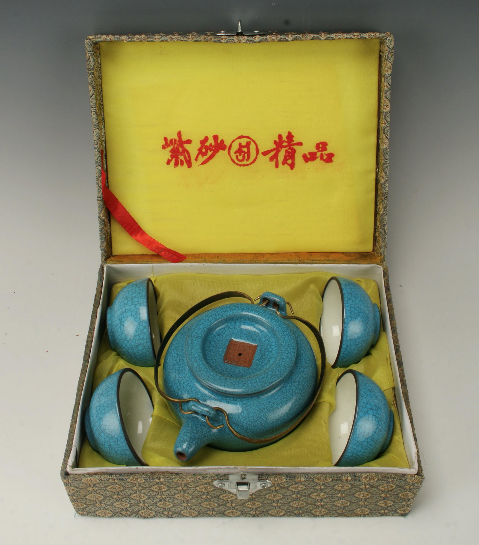 FOUR CUP TEA SET IN BOX: Tea pot and four cups in bright blue with all over craquelure. Each cup has two characters on the inside. Tea pot has mark on lid and bottom with attached wire handles. 8 1/2" X 7" $40 -