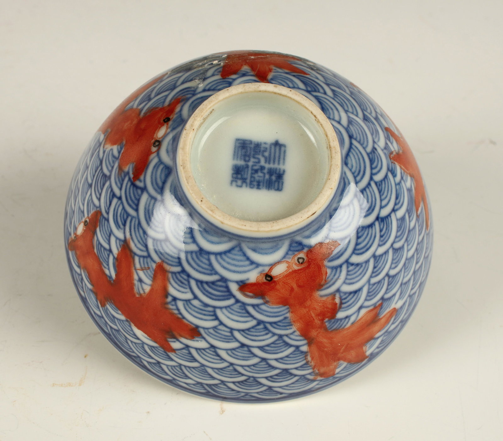 CHINESE PORCELAIN GOLDFISH TEA CUP: Outside has an overall blue and white wave pattern with telescoping eye goldfish. The inside has a central goldfish. Marked on the bottom. 3" x 1 1/2" $200 - $400 Please contact us fo