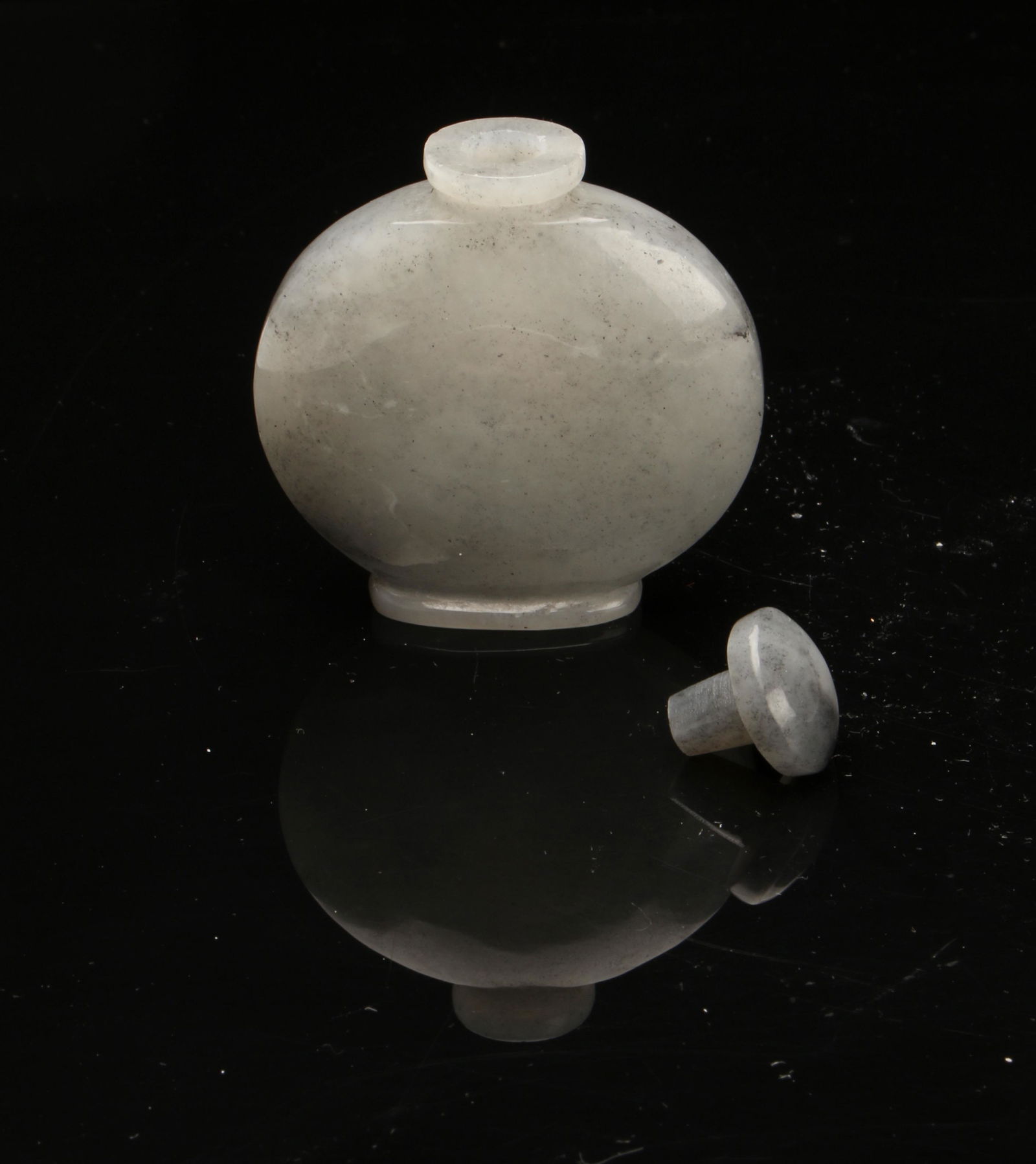 JADE SNUFF BOTTLE: Round jade body and stopper. Polished rounded form on low foot. Provenance: private collection. 2 $100 -