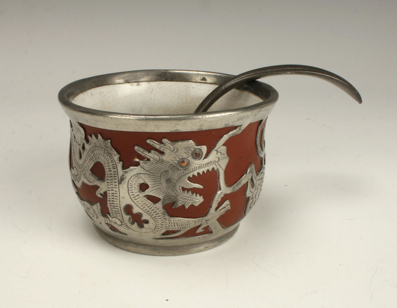 DEH YU PEWTER TERRA COTTA DRAGON BOWL: Marked on the bottom Deh Yu, and Wei Hai. Includes a pewter spoon. Dragons accented with copper eyes and flower centers. 5 1/2" x 3 3/4" $40 - $80 Please contact us for high resolutio