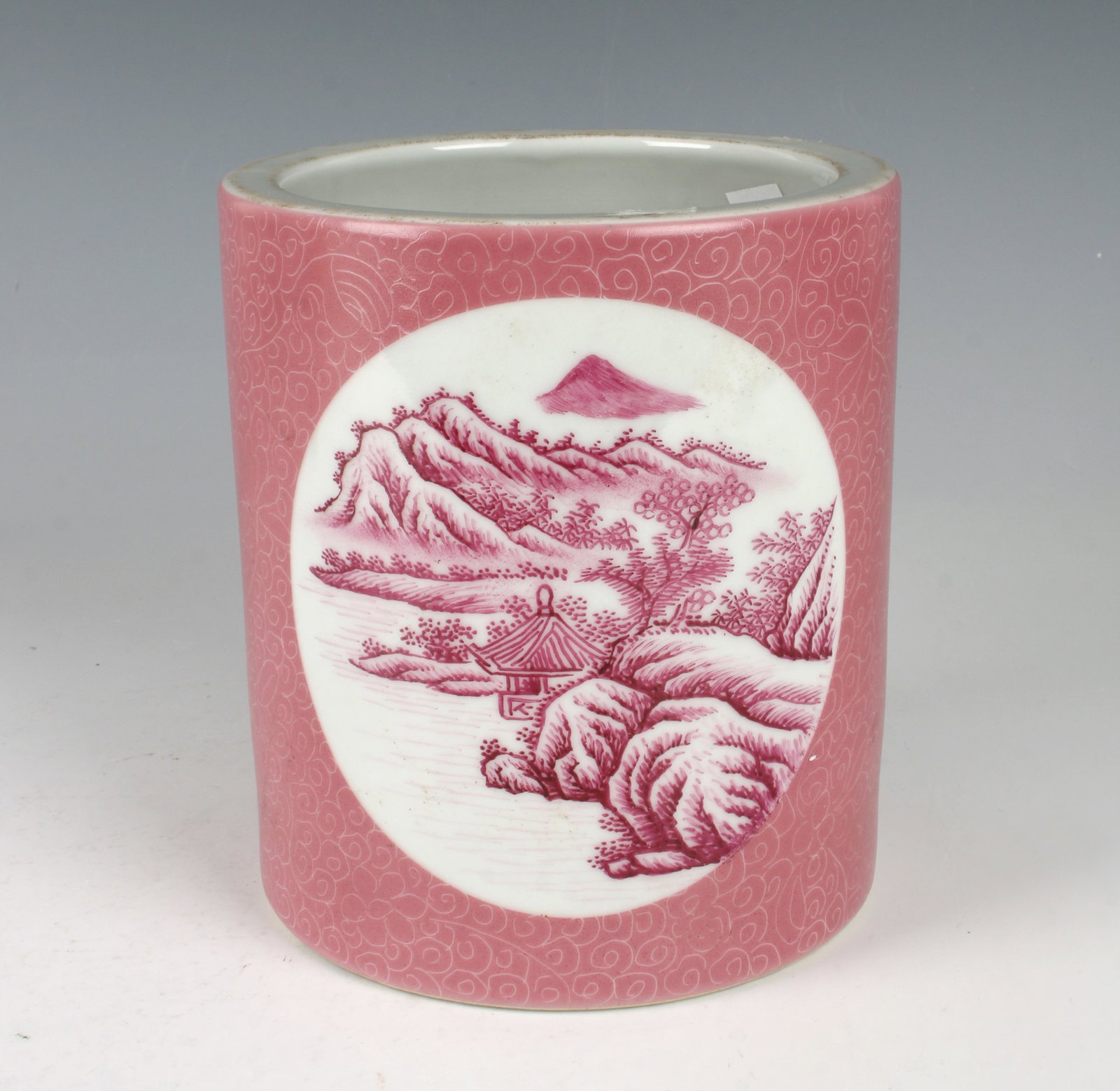 PINK PORCELAIN BRUSH POT: The body has two reserves of a riverside village on either side. The rest is surrounded by pink with delicate swirls and flowers. Marked on the bottom. 6" X 6" $200 - $400 Please cont