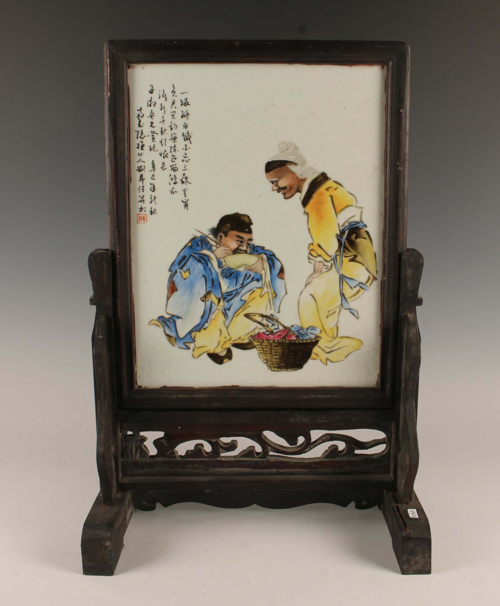 PORCELAIN TABLE SCREEN IN WOOD FRAME: A traveler stops to get a bite to eat. Calligraphy and artist mark on left. In carved and pierced wooden stand. 12" X 19" $200 - $400 Please contact us for high resolution images of th
