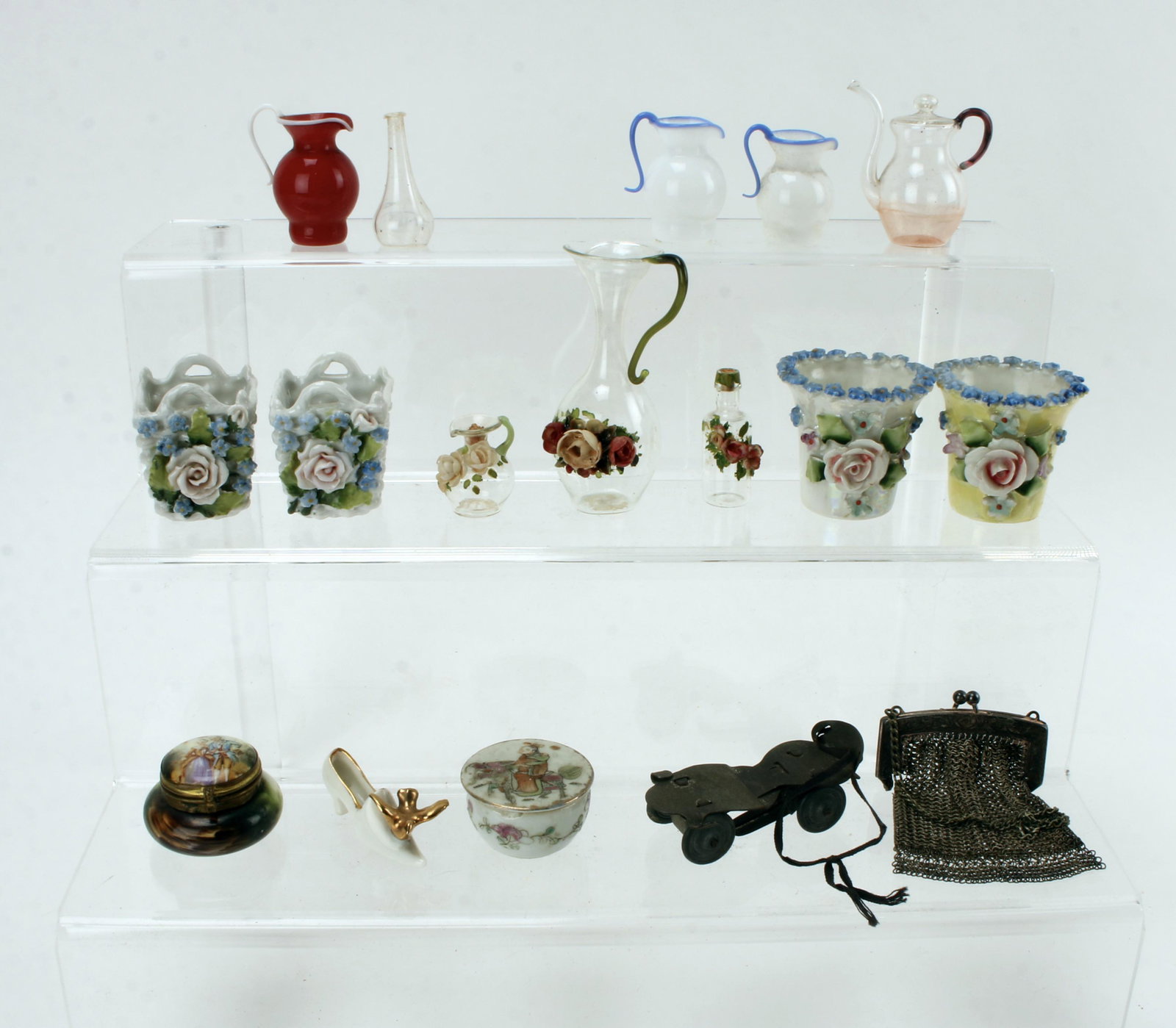 ASSORTED DOLL HOUSE PORCELAIN GLASS FURNISHINGS: Porcelain flower pots marked Germany, glass pitchers, small lidded jars marked Dresden. Mesh bag and roller skate. $40 - $80 Please contact us for high resolution images of this lot. Shipping: