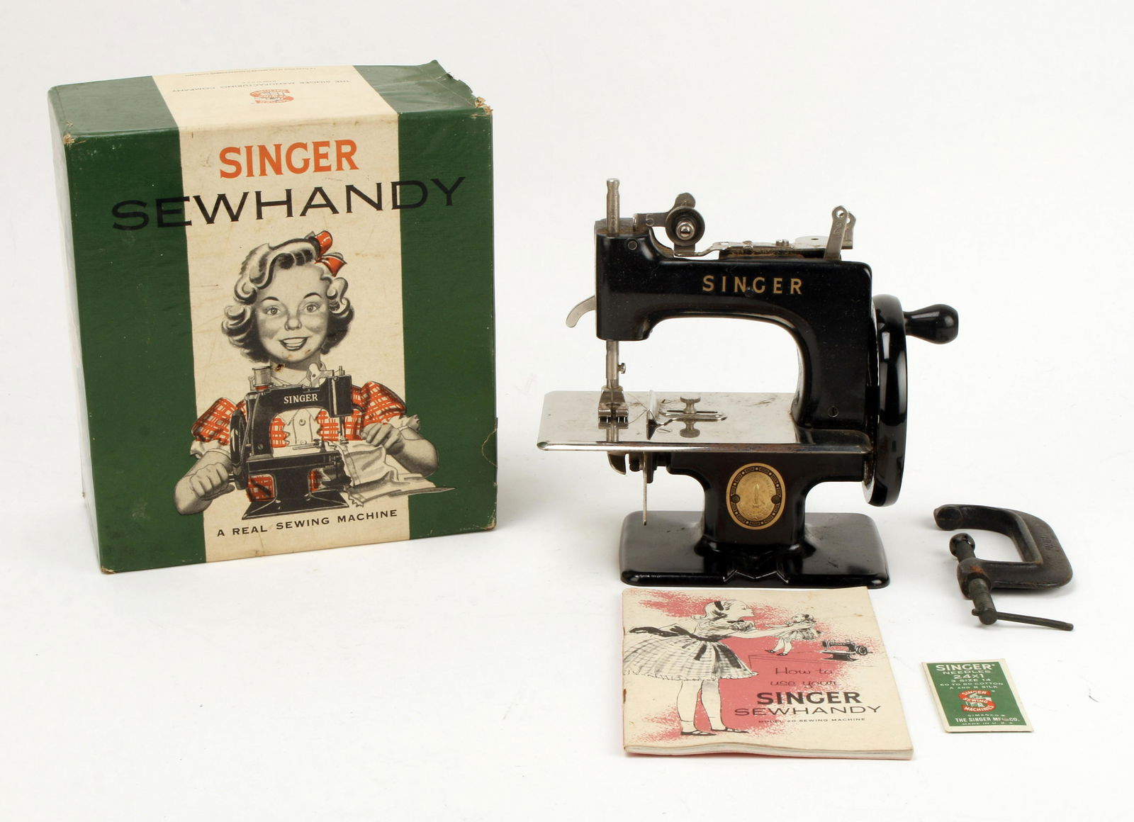 COMPLETE SINGER SEWHANDY SEWING MACHINE IN BOX: Model 20 marked on booklet, copyright 1953. Comes with clamp for attaching to a table. 7" X 7 1/2" $200 - $400 Please contact us for high resolution images of this lot. Shippin