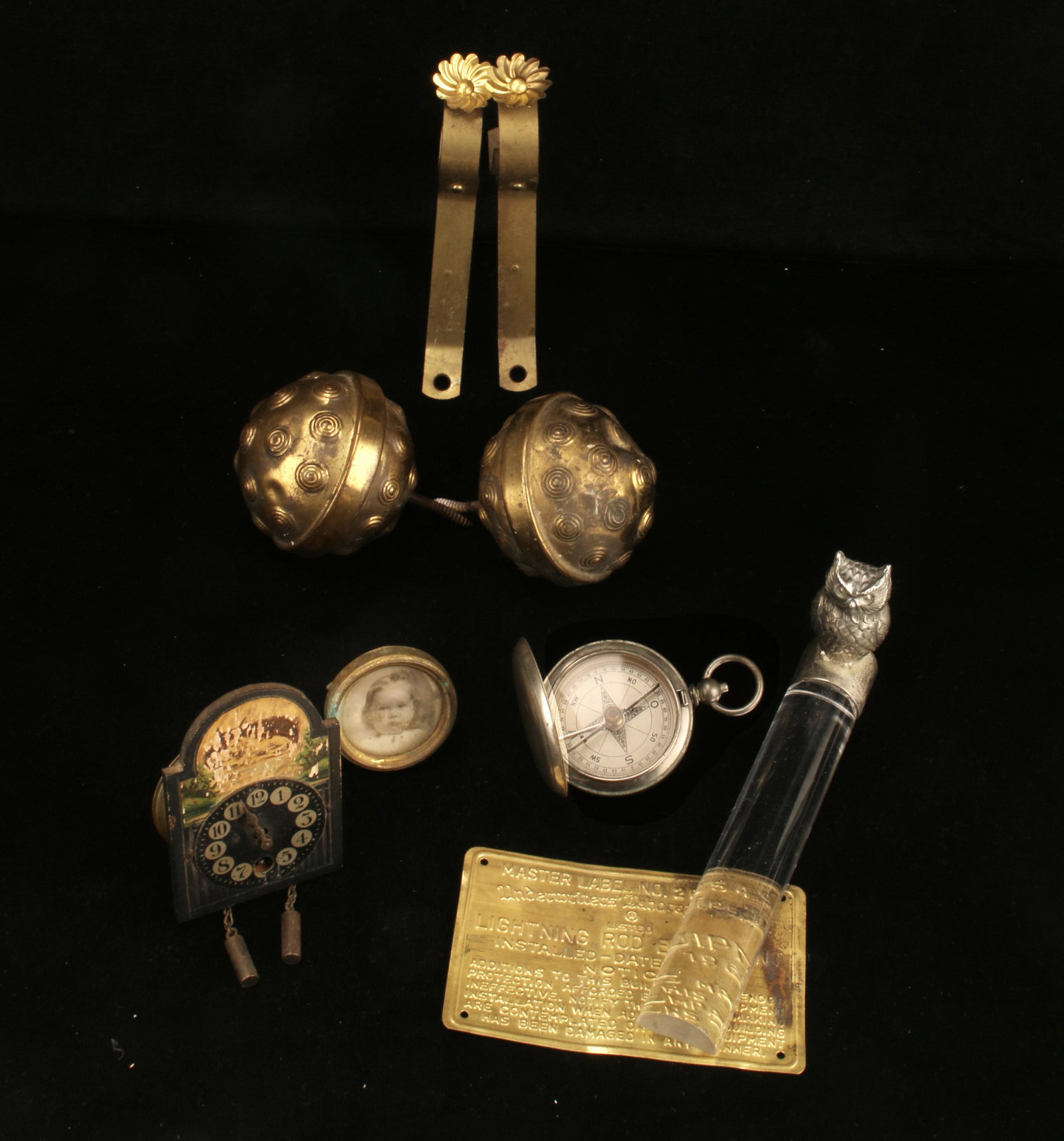 VINTAGE BRASS LOT, TIEBACKS, MAGNIFIER, COMPASS: Victorian Curtain Tiebacks, compass that opens like pocket watch, owl fhandle glass bar lens magnifier, picture frame, plaque. $40 - $80 Please contact us for high resolution images of this lot. Shipp