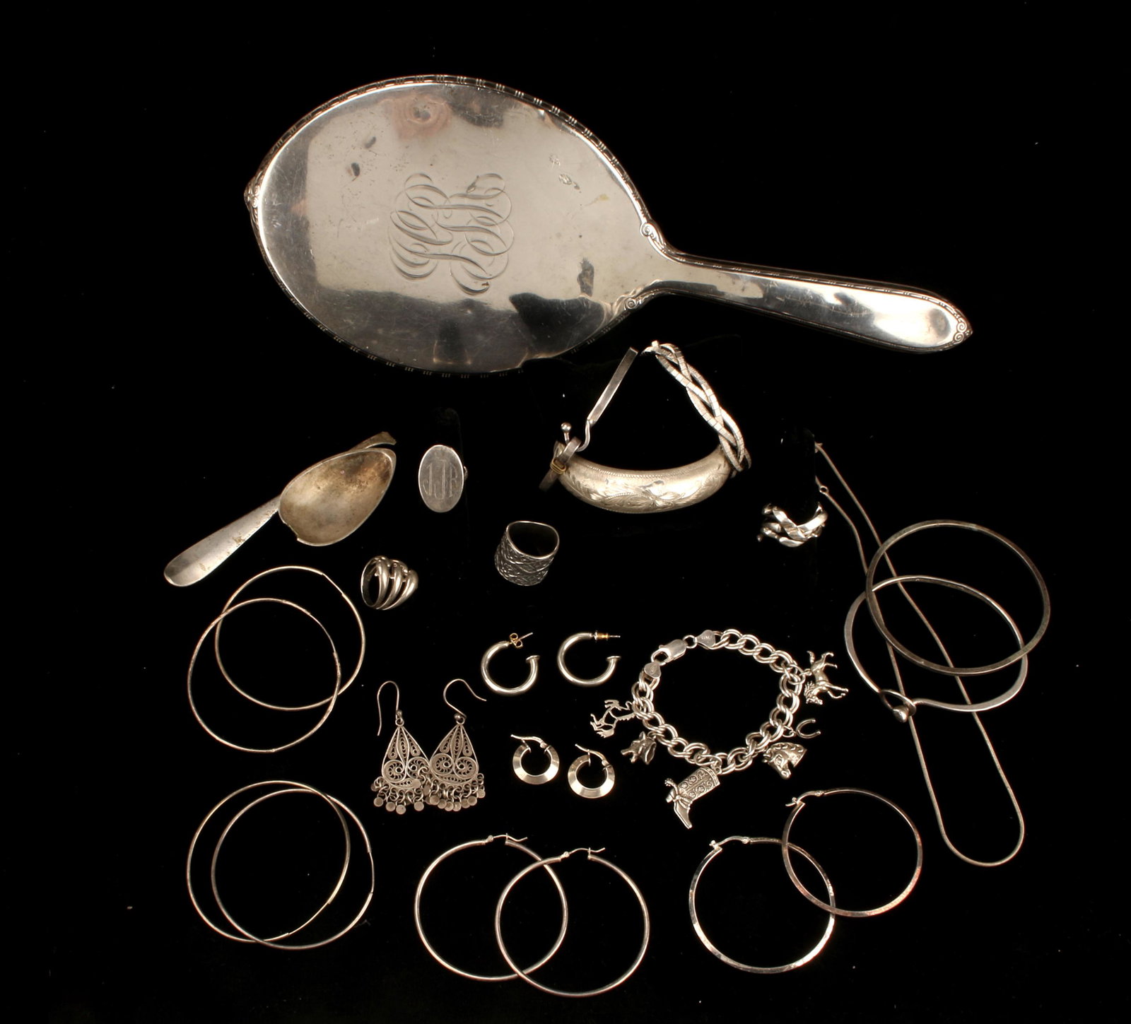 STERLING SILVER JEWELRY & VANITY MIRROR: Various hoop and other Earrings, rings, cowboy charm bracelet, hinged bangle and other bracelets, chain, and hand mirror. 143.9 gms for jewelry. Mirror 269.7 gms. 12" $100 - $200 Please con