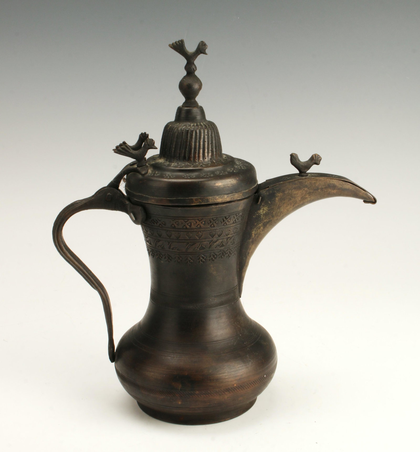 MIDDLE EASTERN DALLAH COPPER COFFEE POT: Four roosters on top of handle and lid, fly guard on spout. Decorative borders on the body. Provenance: Found in Eastern Saudi Arabia at Hofuf oasis. 10" x 8 1/2" $40 - $80