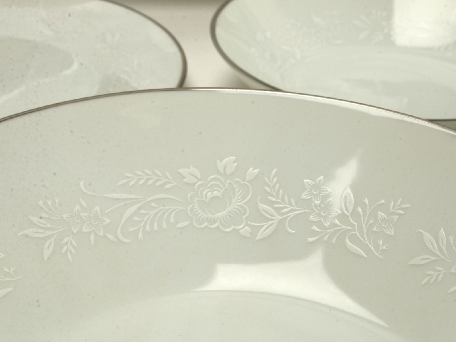 NORITAKE REINA COMPLETE SERVICE FOR 12: White on white flowers and leaves with platinum rim. 20 cups, 19 saucers, 11 fruit bowls, 12 bread and butter plates, 12 soup bowls, 2 sets sugar and creamer, 1 large tea pot, 2 oval platters, round s