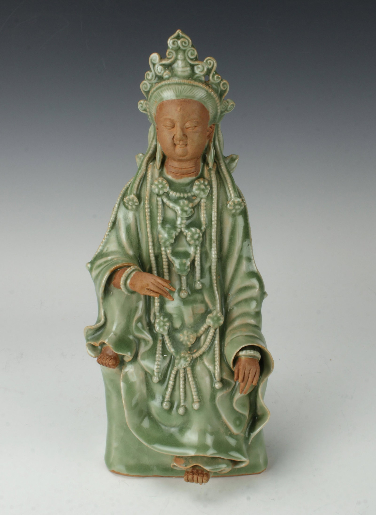 ANTIQUE CELADON & UNGLAZED TERRA COTTA BUDDHA: In celadon and unglazed terra cotta. The skin is left unglazed and left in the clay's natural color. The pedestal and clothing are glazed in a soft green celadon. 11" X 4 1/2" $300 - $500