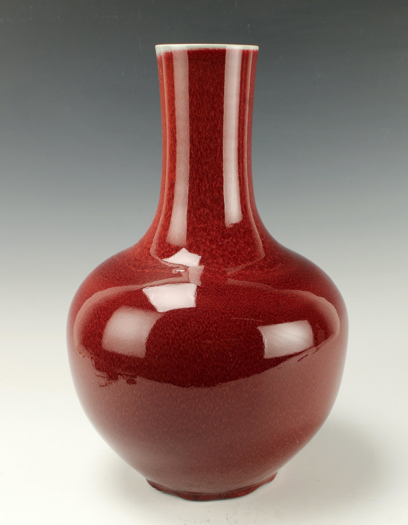 GLOBULAR OXBLOOD VASE: Wide body with thinner neck, the rim reveals the celadon color gradating down to the dark oxblood glaze. All over ox blood glaze. 9" X 15" $100 - $200 Please contact us for high resol