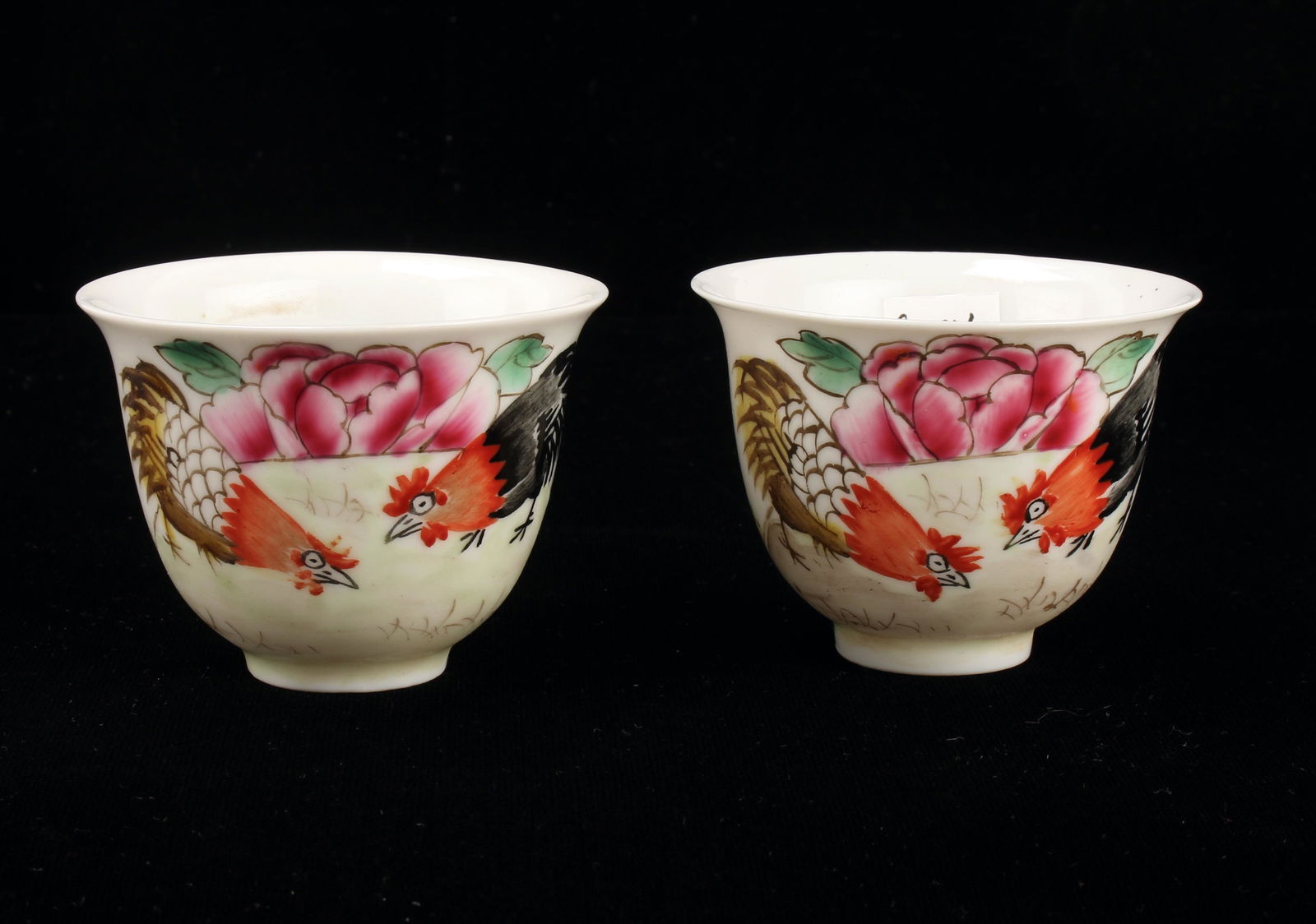 PAIR OF ROOSTER TEA CUPS: Two roosters pecking in a garden with a large flower behind them. Marked on the bottom. 2 3/4" X 2" $200 - $400 Please contact us for high resolution images of this lot. Shippi