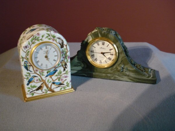 Two desk clocks : Two small 20th C. desk clocks with quartz clocks. One with a chip, marked Halycon David Enamels; the other Aynsley "Portlandware". Also, a small oval easl form frame goes with the Halycon clock.