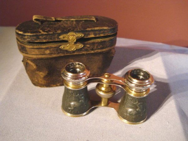 Opera Glasses: Opera glasses in leather case, with the barrels being a gun metal bas relief depiction of a stag hunt. Losses of lining of interior case lid and handle broken.