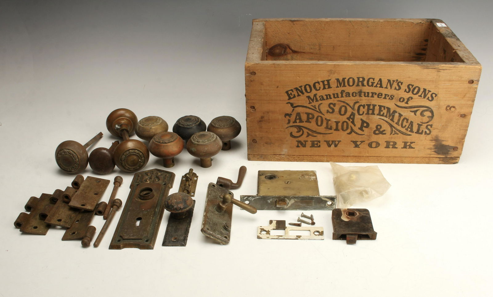 ANTIQUE VINTAGE DOOR HARDWARE & ADVERTISING CRATE: Various decorative vintage & antique doorknobs, hinges, latches, window latches etc. one latch marked Russell & Erwin Mfg. Co. New Britain. Crate is marked Enoch Morgan's Sons Sapolio, Soap, &