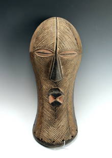 SONGYE SONGUE MASK CONGO: Songye Songue Mask CongoIncised with diagonal lines with slits for eyes and elongated triangular nose, and protruding pink and black mouth. Chisel marks evident on back side. 16" X 7" $100