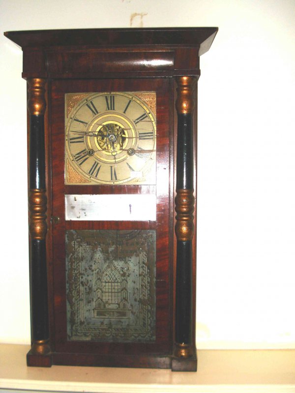 Brige Mallory Connecticut shelf clock: A half column shelf clock with a single front door opening to a weight driven clock labeled by Birge, Mallory & Co.. The etched glass bottom glass shows a Gothic window, central is a looking glass and