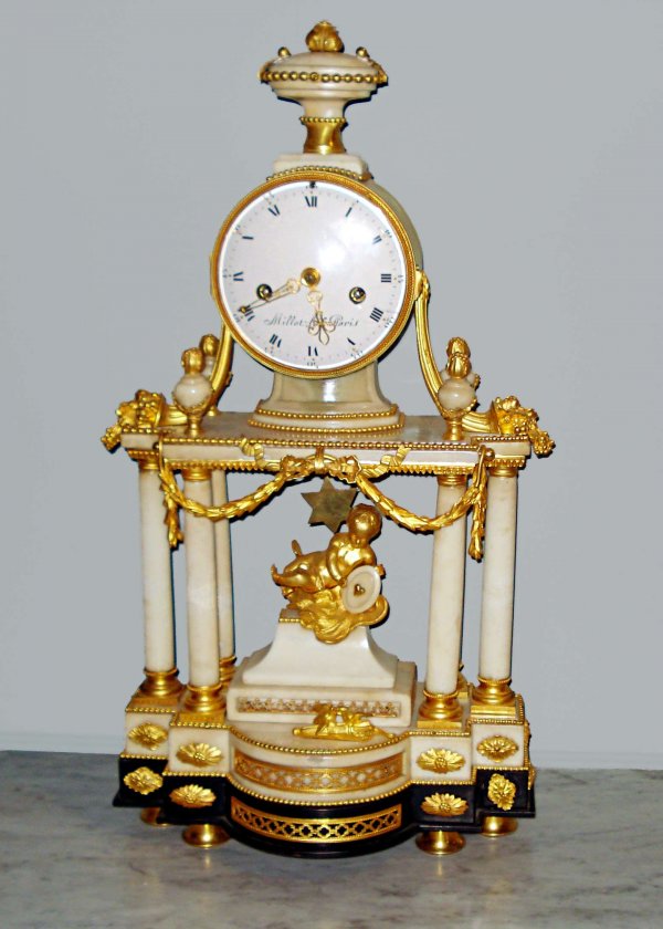 French Louis XVI clock: A late 18th or early 19th century marble and ormolu mount clock signed as Parisian in origin. The four fluted pillars rise from the marble base to support a frieze enclosing a clock with a circular po