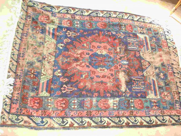 Throw rug: A Caucasian throw rug, 47" X 72". Worn areas at both ands.