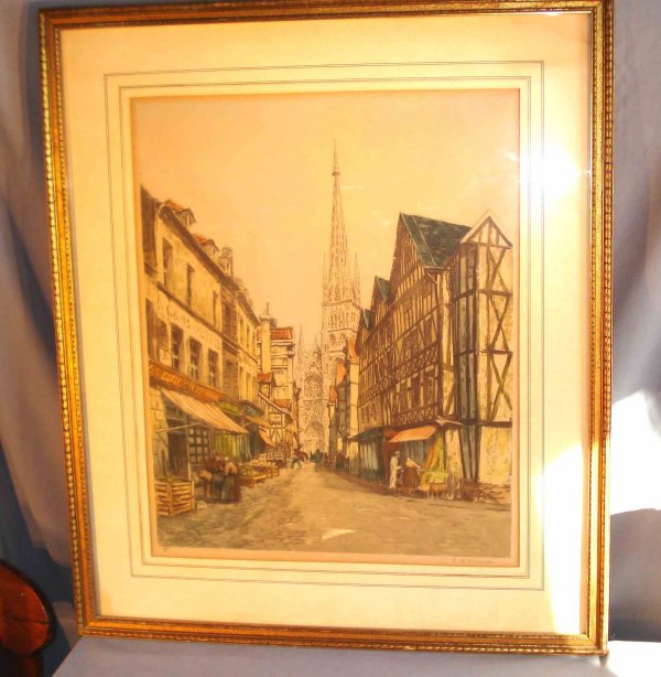 Colored etching by V. D. Maneer : A colored etching of Rouen, France. Signed in pencil lower right "V D Maneer" with triangular mark 18" X 21 1/2", and labeled in reverse. Within a gold leaf frame and custom mat.