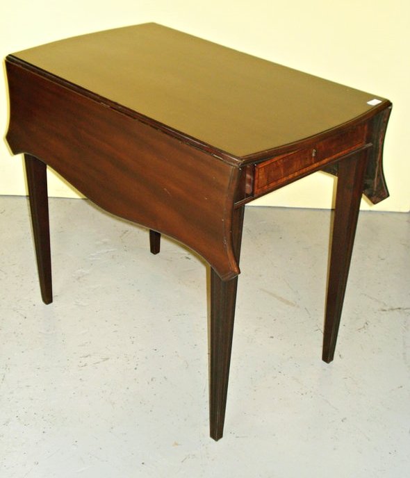 Pembroke or drop leaf table: A solid mahogany 19th Century Georgian Pembroke table, 27.5"H x 36.5"W x 32"D. The leaved with shaped corners and having one work drawer (with dividers missing), and square tapered,molded legs