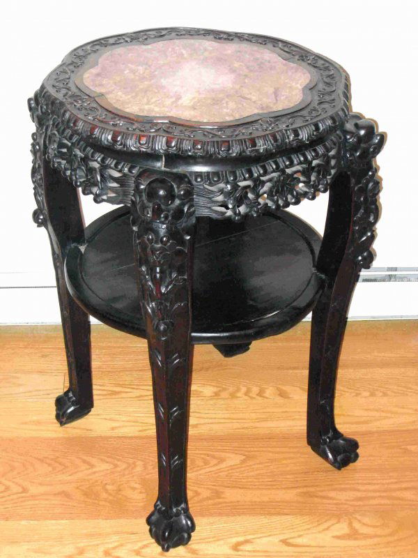 Chinese carved ebony and marble side table: A heavily carved solid rosewood end table mounted with a marble top. The height is 32" and across the top is 22".