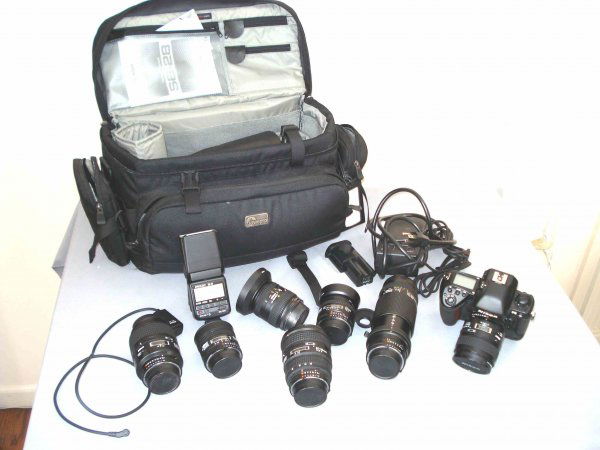 Nikon Camera and lenses: Nikon F5 model camera and assorted fitted Nikon lenses, including 16mm, 35mm,20-25mm, 24-50mm,60mm, 105mm, 75-300mm. Includes carrying case, battery charger, flask attachment, and single lens reflex N