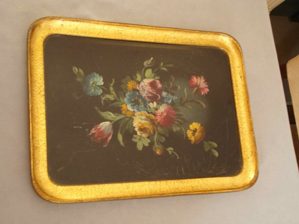 Painted tray: A wood or composition tray, 15" X 11 1/4" painted in the tole manner with flowers in bloom against a black background and a gold border.