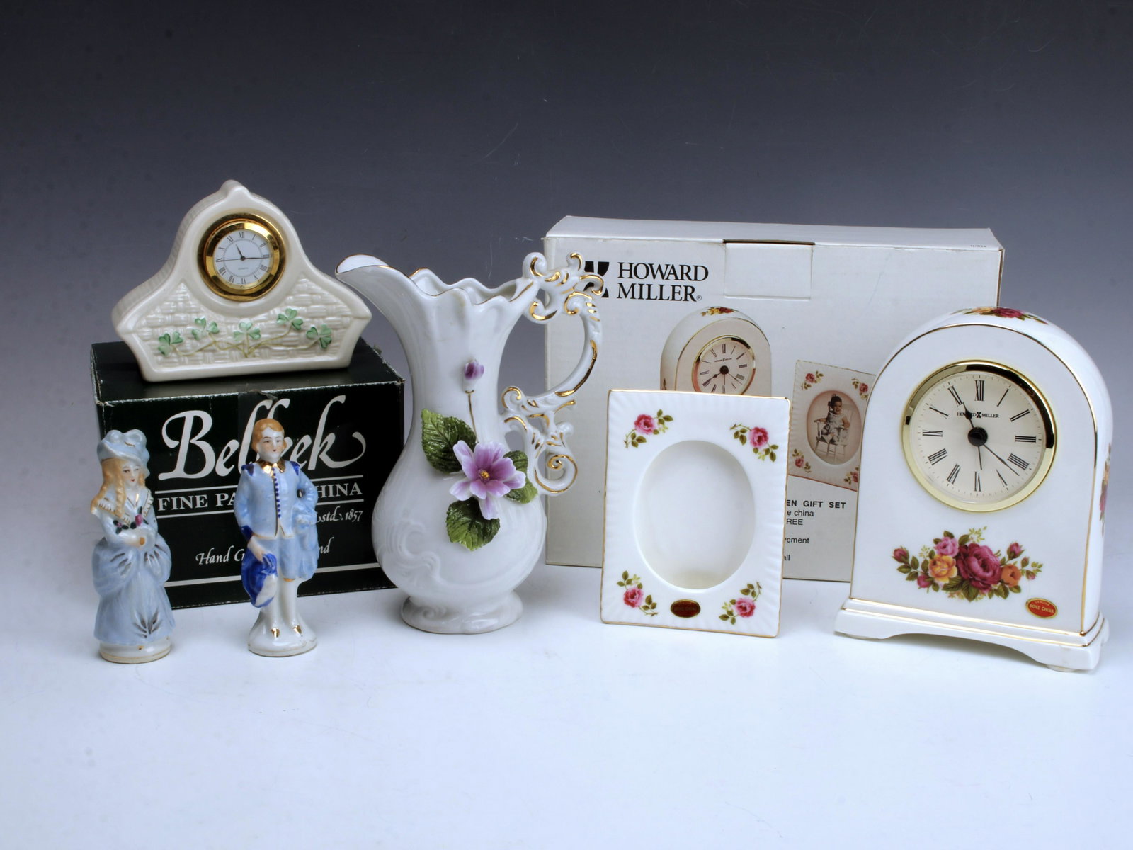 PORCELAIN LOT CLOCKS & FIGURINES BELLEEK: PORCELAIN LOT CLOCKS & FIGURINES BELLEEK 1 Belleek Killarney clock in box, marked Belleek Ireland. Howard Miller English Garden Gift Set with clock and picture frame new in box. Smal