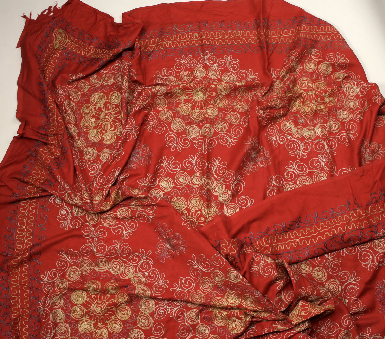VINTAGE RED EMBROIDERED SUZANI FABRIC: VINTAGE RED EMBROIDERED SUZANI FABRIC Embroidered in yellow, blue, tan, and purple. Could be used as a bed cover or wall decoration. 83" X 134"</