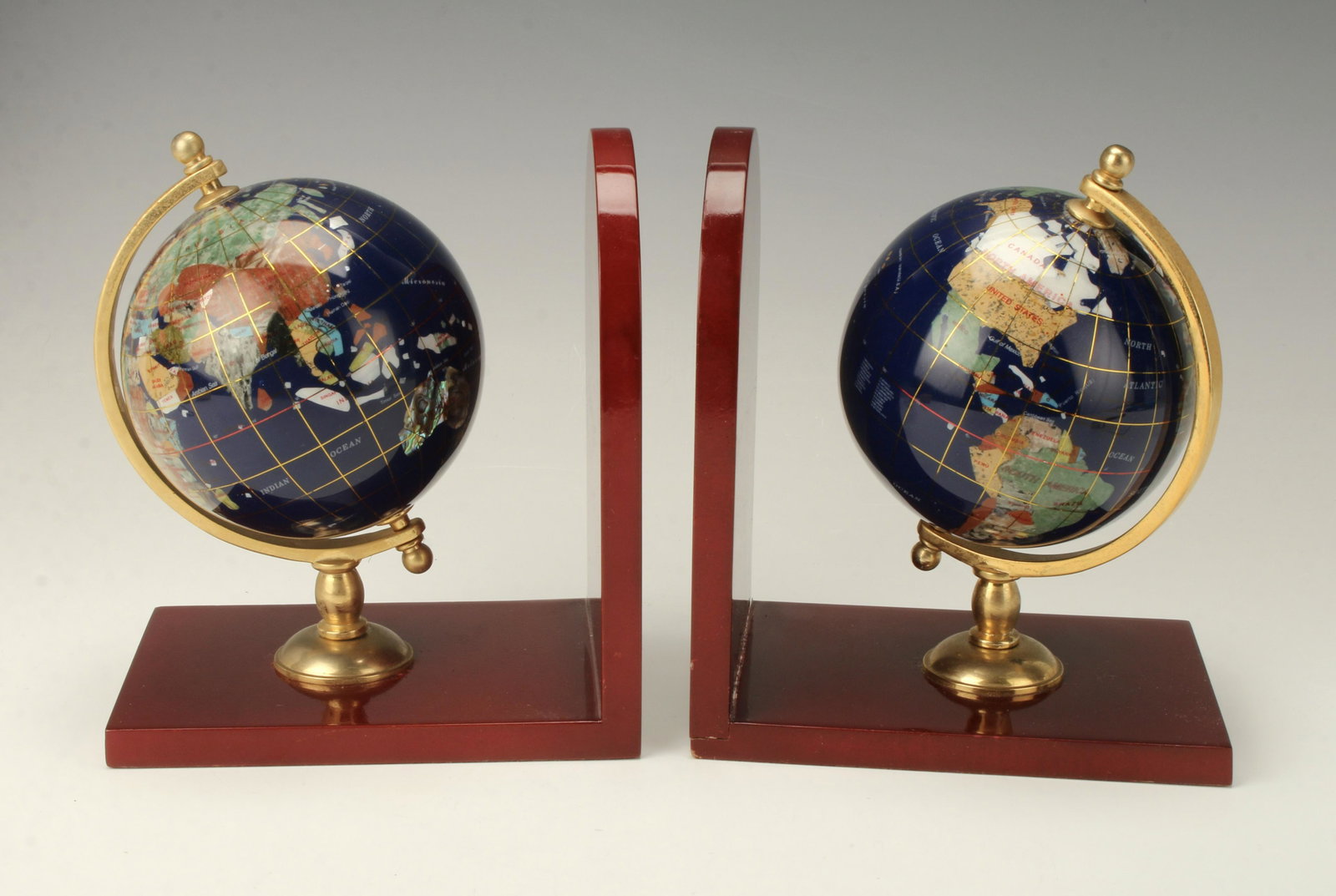 PAIR WOOD & INLAID STONE GLOBE BOOKENDS: PAIR WOOD & INLAID STONE GLOBE BOOKENDS Burgundy lacquer wood frame with brass globe holder. Globe is inlaid with numerous colorful stones representing the countries.