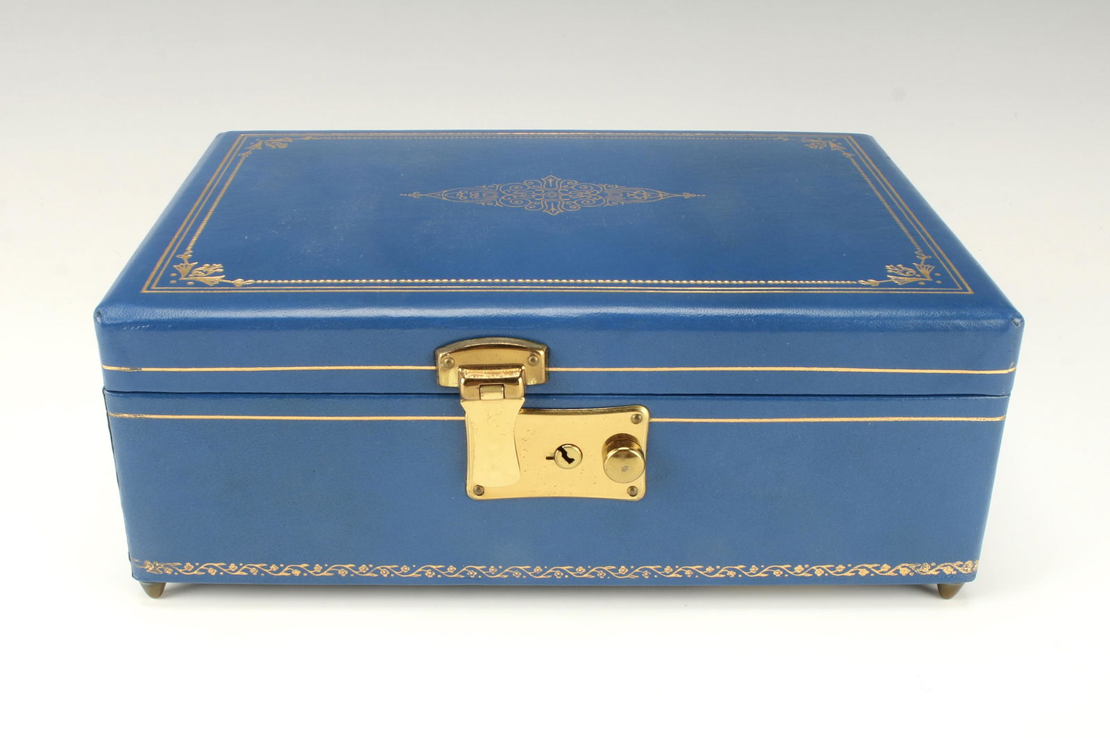 JEWELRY AND MUSIC BOX: JEWELRY AND MUSIC BOX Blue leather jewelry box with Thorens musical movement, plays Star Dust, 24k gold tooling, with lock and key, made in Switzerland. 10