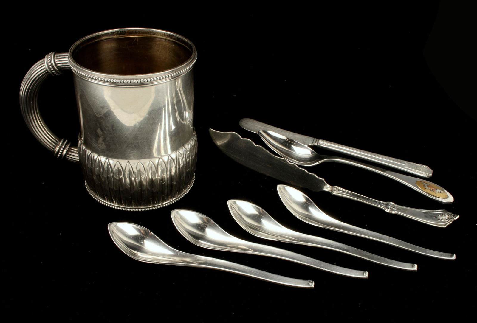 STERLING REED & BARTON MUG, HANS HANSEN SPOONS: STERLING REED & BARTON MUG, HANS HANSEN SPOONS Sterling mug with leaves border at the base and cylindrical lined handle. Includes 4 sterling Mid Century espresso spoons by Hans Han