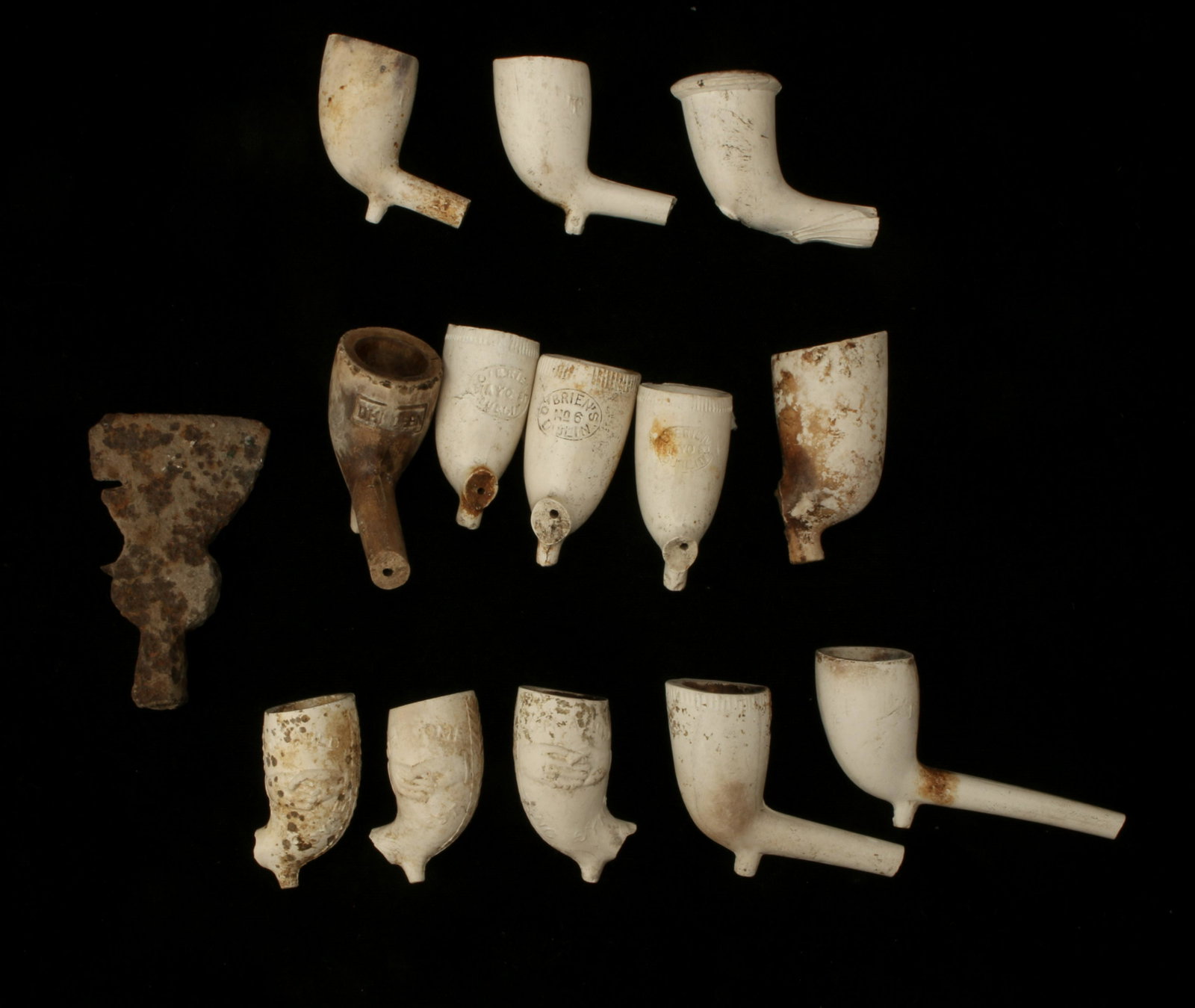 ANTIQUE WHITE CLAY PIPES AND HATCHET HEAD: ANTIQUE WHITE CLAY PIPES AND HATCHET HEAD Includes O'Brien's Dublin, Lang Syne, and various unmarked pipes. Also in this lot is an old hatchet head. 2&quo