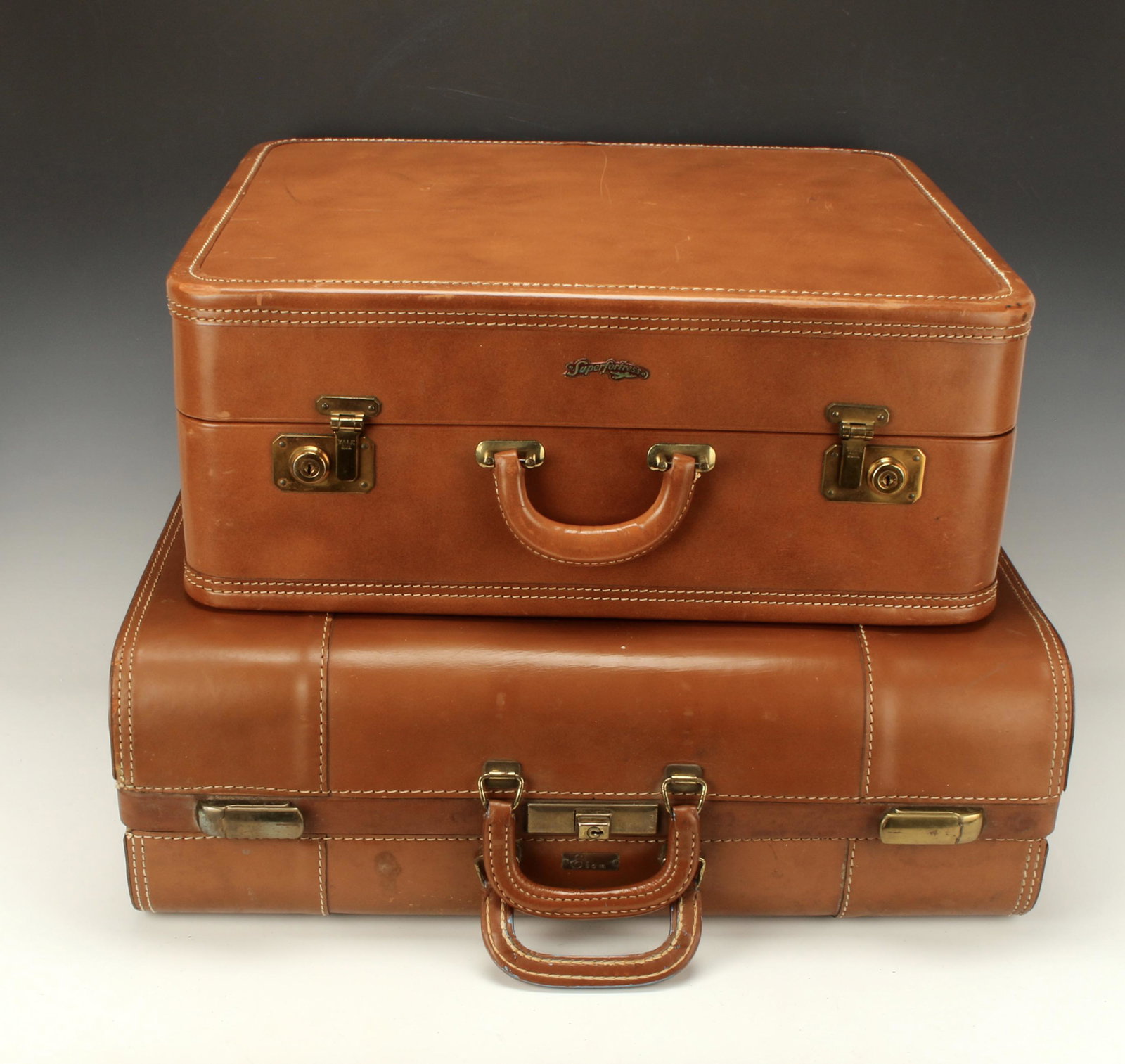 TWO VINTAGE SUITCASES IN TAN COWHIDE: TWO VINTAGE SUITCASES IN TAN COWHIDE Both marked Genuine cowhide. One has keys, original metal dividers, hangers, Yale brass latches. Marked Super Fortress. The other includes two metal