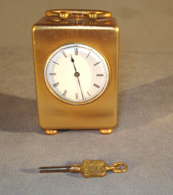 Brass Desk Clock : A small desk clock, later fit with a 19th century stem wind and stem set watch movement. 2 3/4" in height. Runs and stops.