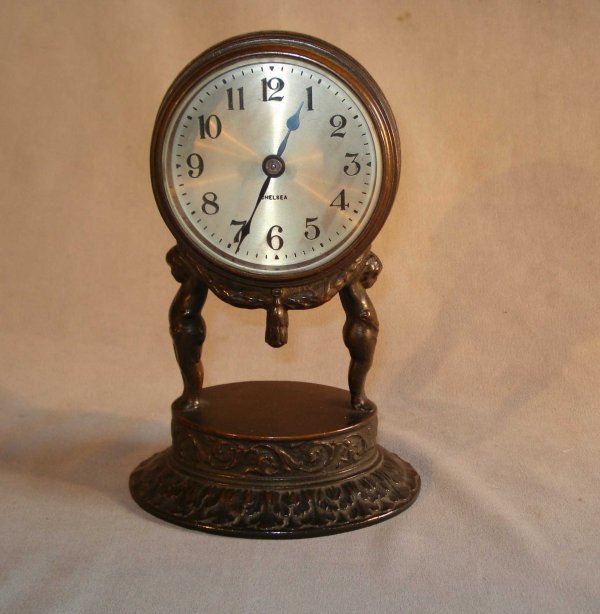Chelsea Bronze Desk Clock : A 7" cast patinated bronze desk clock with an eight day Chelsea balance wheel timepiece having a silvered dial.
