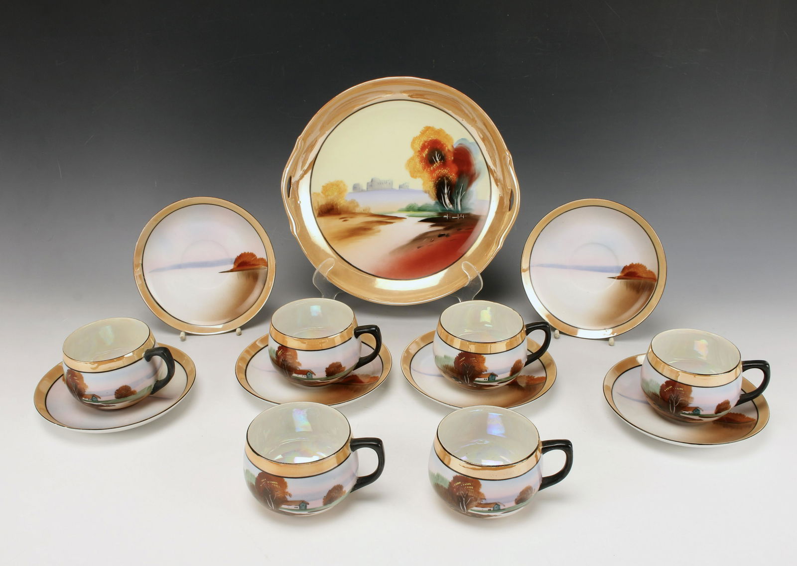 CHIKARAMACHI HAND PAINTED LUSTER CUPS SAUCERS TRAY: CHIKARAMACHI HAND PAINTED LUSTER CUPS SAUCERS TRAY Six hand painted tea cups and saucers with round tray. All with a lovely landscape. Marked Chikaramachi Made in Japan on bottom.