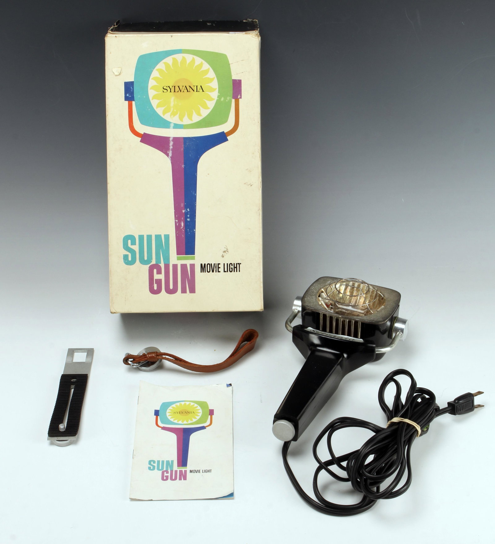 VINTAGE SYLVANIA SUN GUN MOVIE LIGHT ON BOX: VINTAGE SYLVANIA SUN GUN MOVIE LIGHT ON BOX Model SG-1 Sylvania Sun Gun movie light. Includes booklet and camera attachment. Box is very worn. In used condition.
