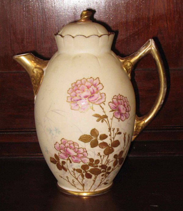 American Ceramic Arts Chocolate pot: 8 1/4" American Ceramic Arts Co Belleek chocolate pot with a lid, hand painted with floral decoration and embossed gold leaves. Gilding on the spout handle and finial, with a purple mark . C 1895.
