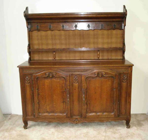 French Vaisselier: A 19th century solid walnut carved French made Vaisselier or buffet with a later added dresser top featuring iron cup hooks and plate rack.