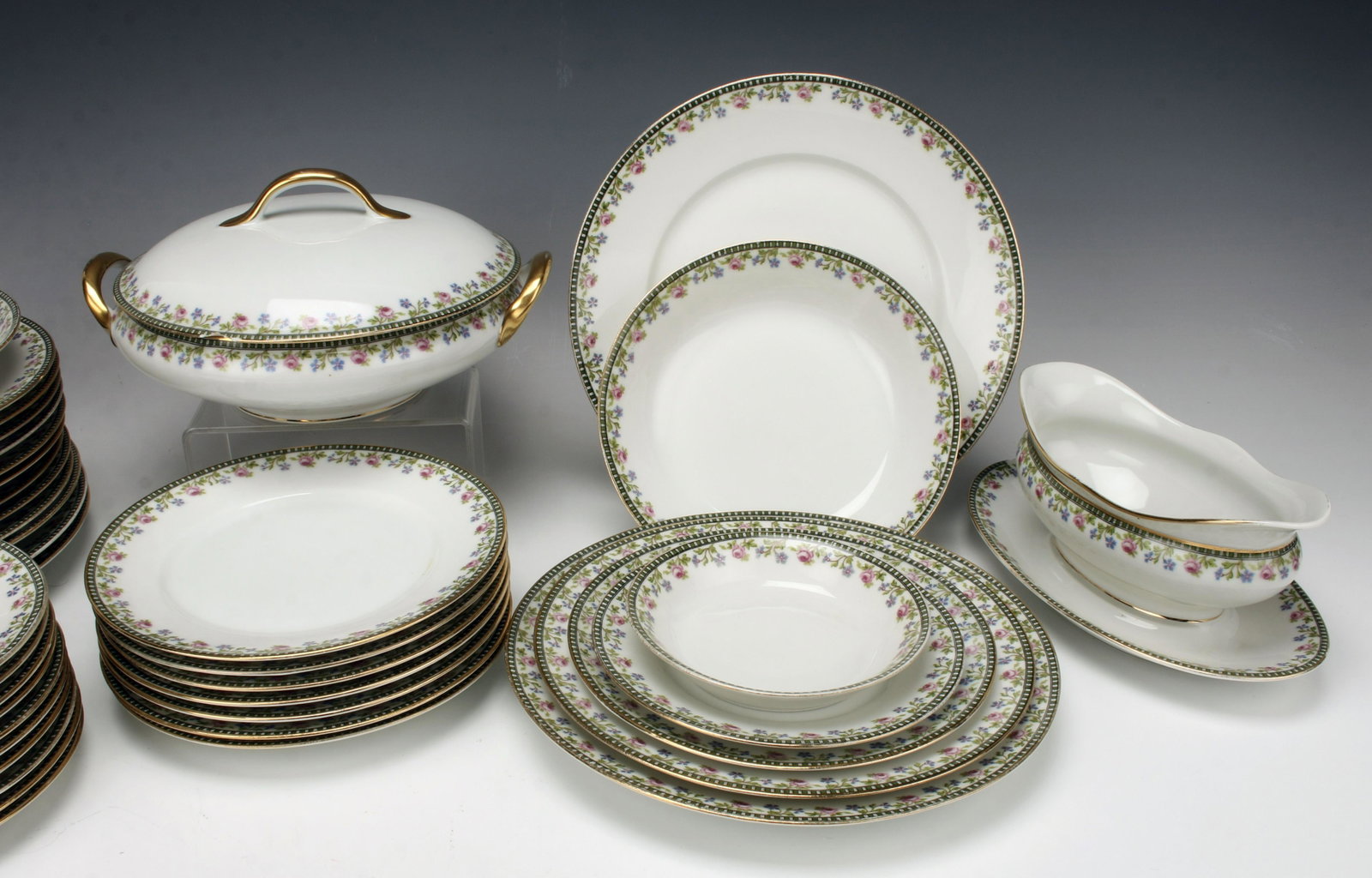 U.C. LIMOGES HAND PAINTED PORCELAIN TABLEWARE: U.C. LIMOGES HAND PAINTED PORCELAIN TABLEWARE In an Art Deco pattern of green and white checks on the rim bordering a small rose and