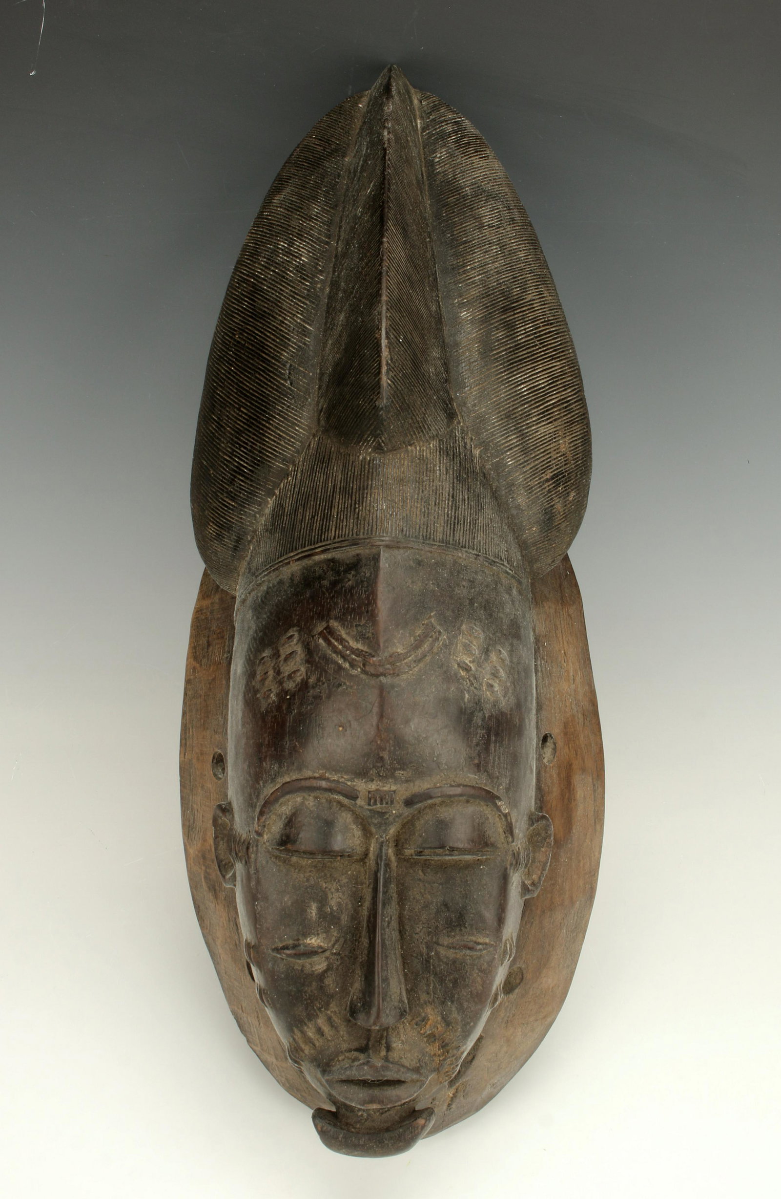 BAOLET YAOURE IVORY COAST MASK: BAOLET YAOURE IVORY COAST MASK Tall incised headdress. The face has a beard and scarification. 20 1/2" X 8" Shipping: